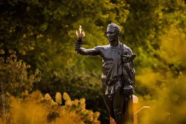 The Torchbearer statue holds an open flame.